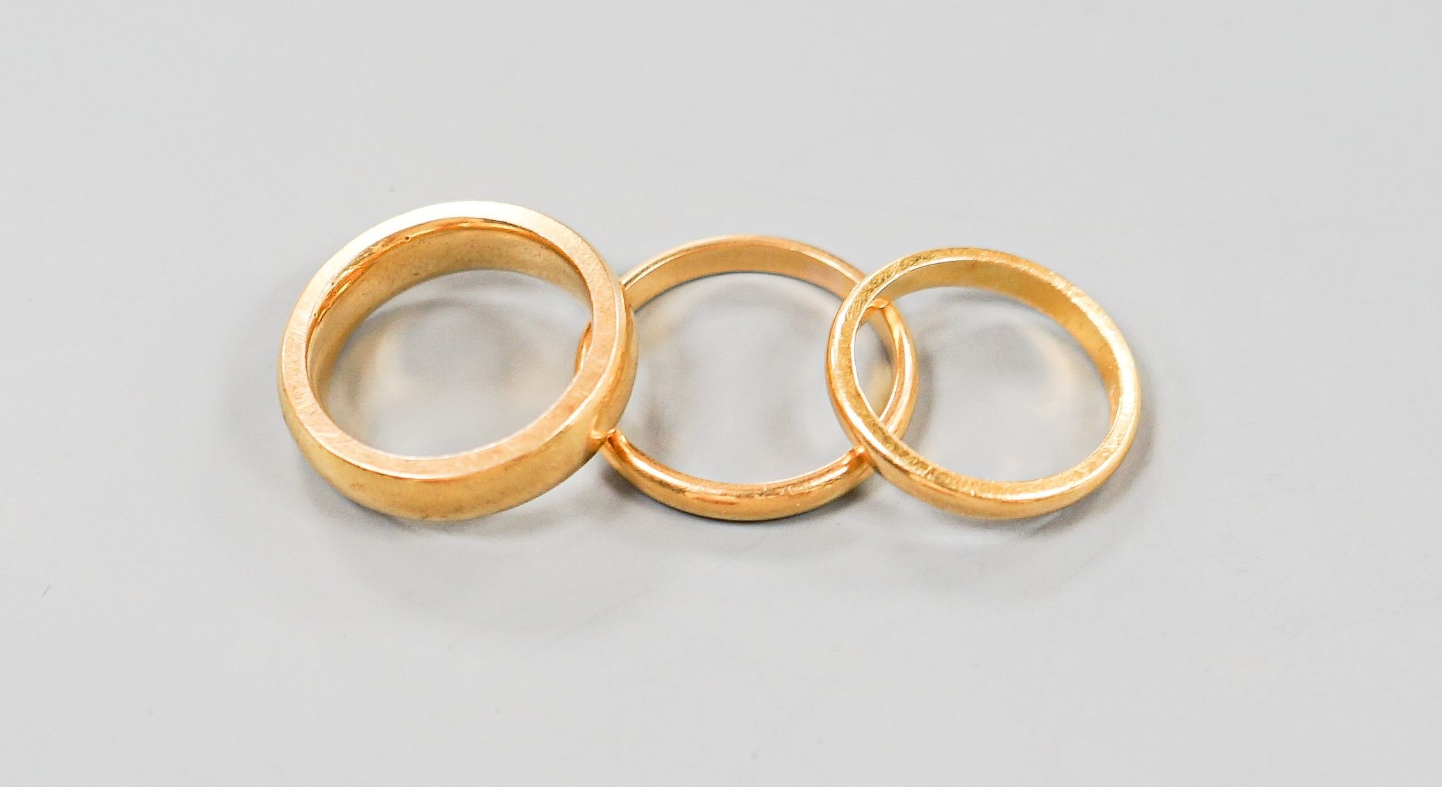 Two 22ct gold wedding bands, 7.1 grams and one other heavy yellow metal band, 12.1 grams.